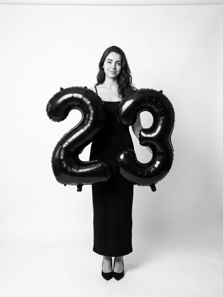 Studio birthday portrait with black number balloons