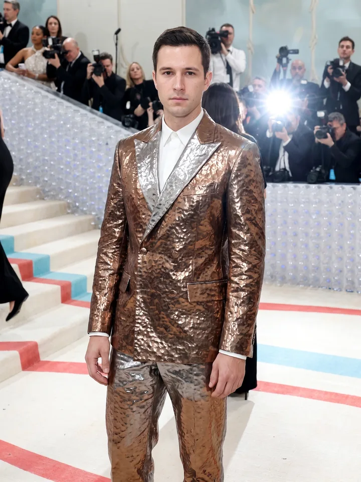 Met Gala tuxedo look on a white carpet by a marble staircase