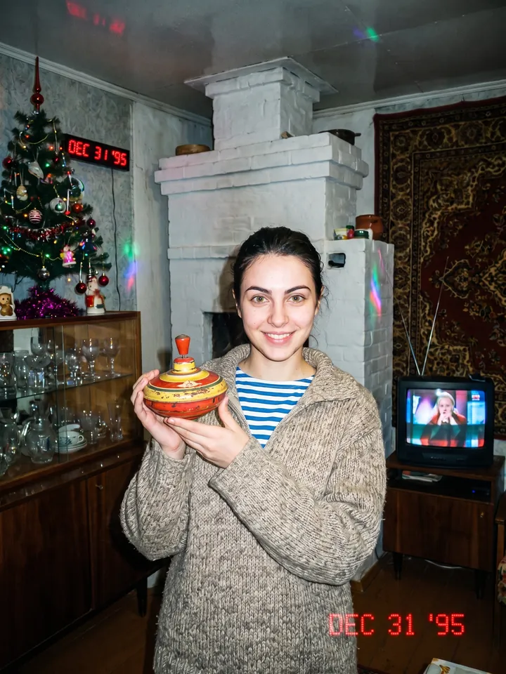 1990s flash snapshot in a village room with a carpet on the wall